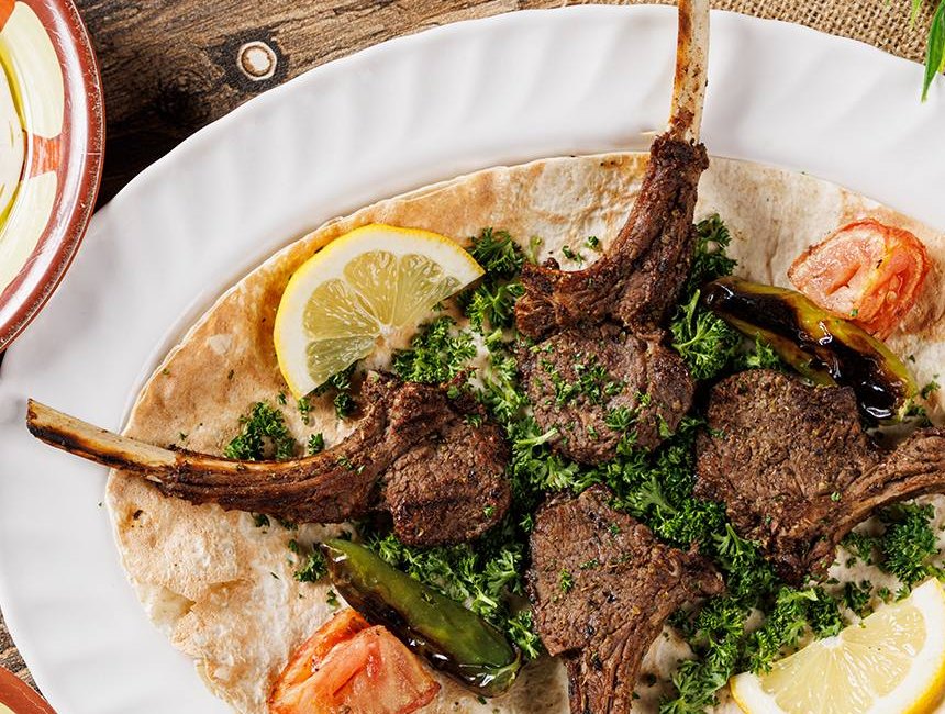 Grilled lamb chops with lemon on a white plate